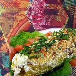 Grilled corn on the cob with white cheese, chili, and cilantro.