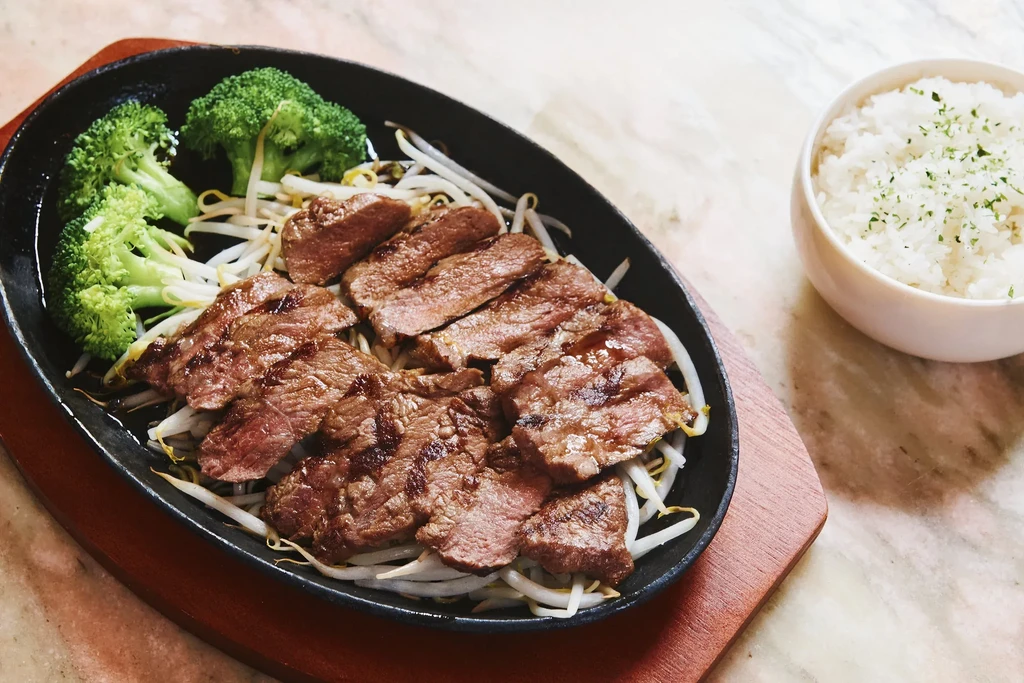 Grilled steak slices with broccoli and bean sprouts, with a side of rice.