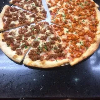 A large pizza with two meat toppings cut into multiple slices.