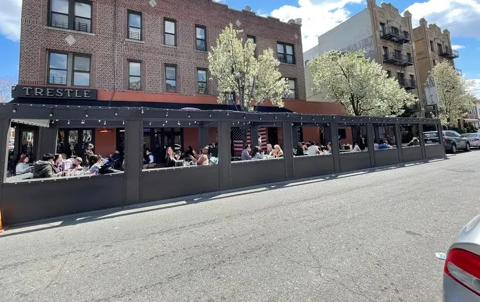 Outdoor dining area on a city street with people eating.