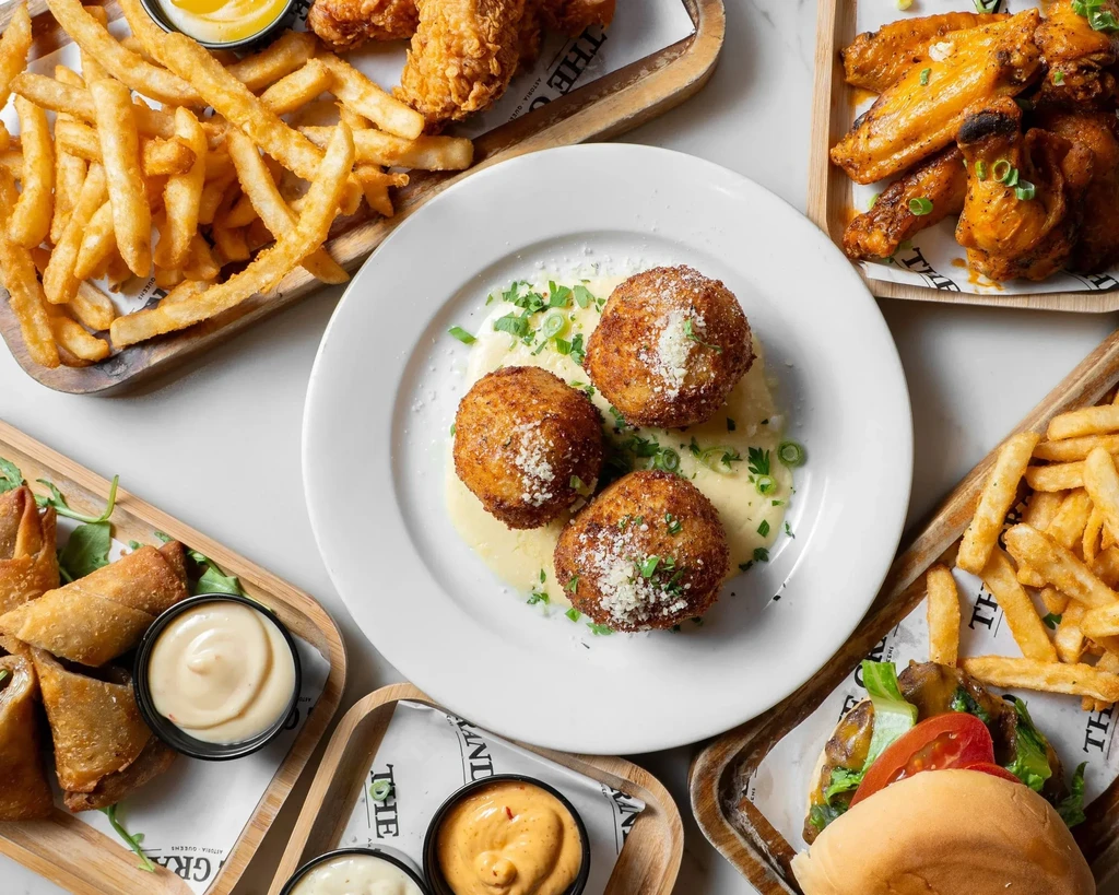 An overhead view of multiple fast-food dishes on a white surface.
