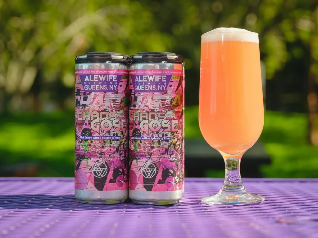 Two Alewife Brewing Chaos Gose cans and a full glass on a purple table.