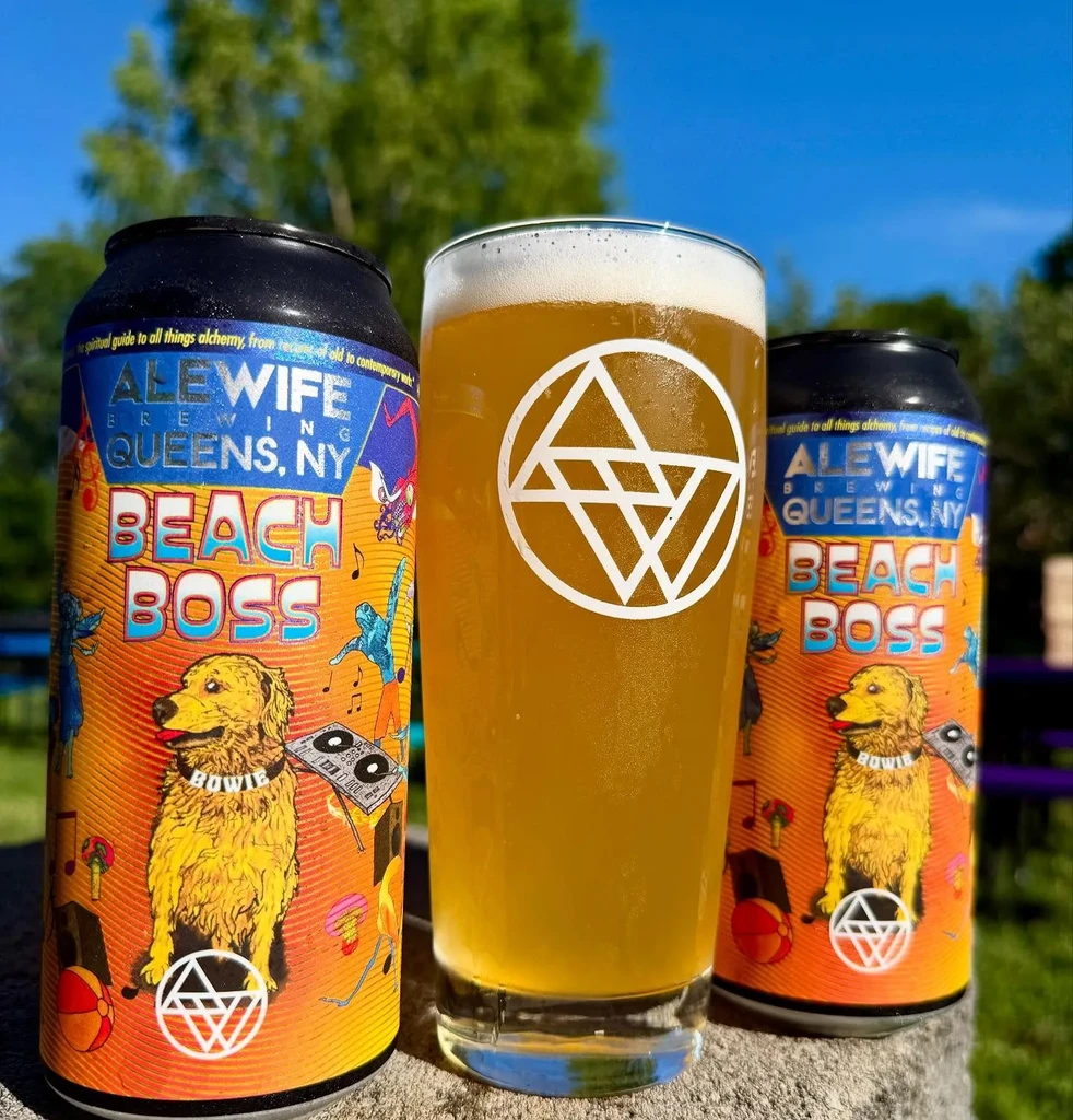 Two cans and a glass of "Beach Boss" Alewife beer outdoors.