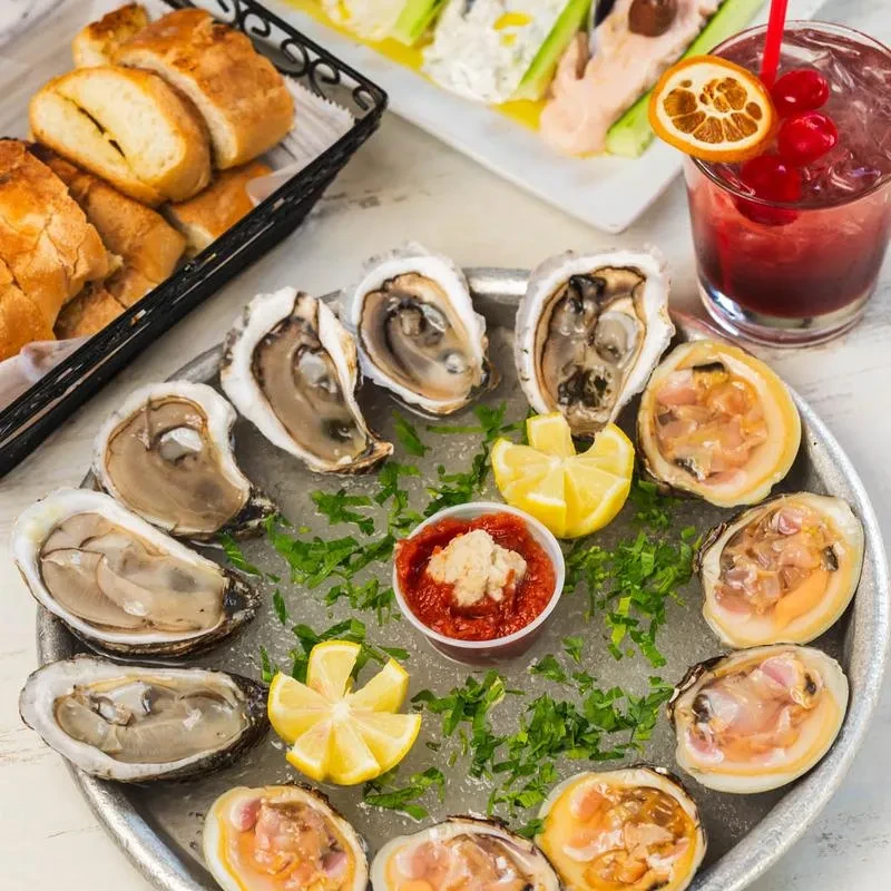 Raw oysters and clams on ice with lemon and cocktail sauce.