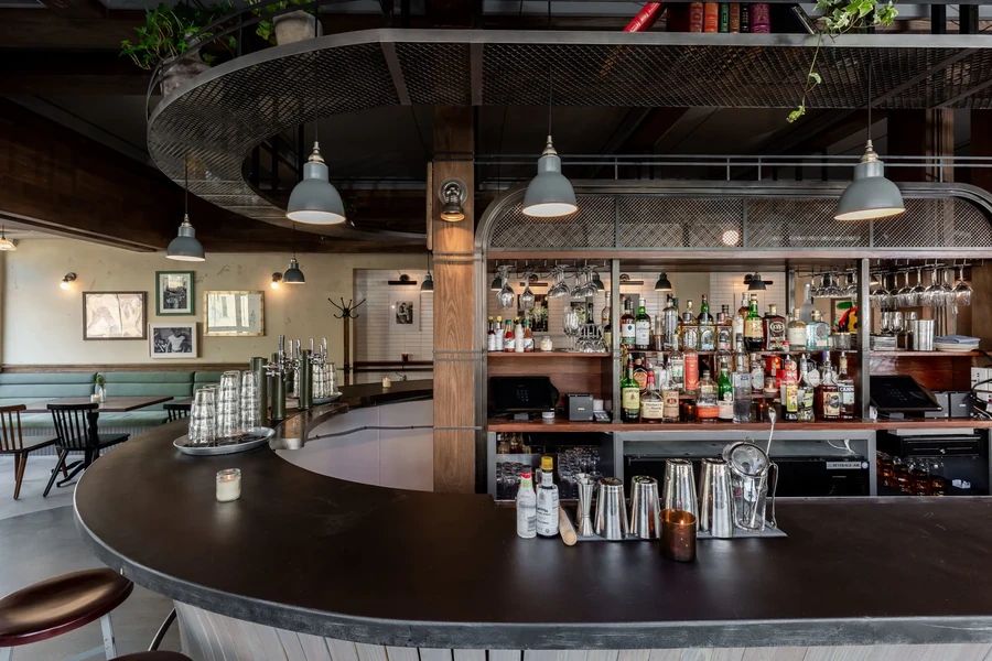 Interior of a modern bar with a well-stocked liquor shelf.