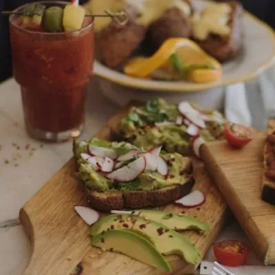 Avocado toast with radishes, a Bloody Mary, and baked potatoes.