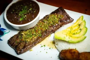 Grilled steak with chimichurri, rice, avocado, black beans, and plantains.