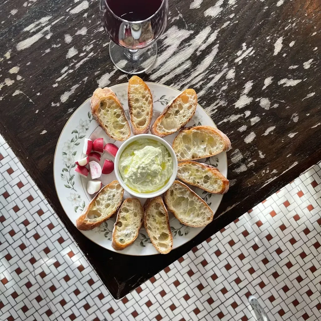Overhead shot of bread, dip, and radishes on a table.