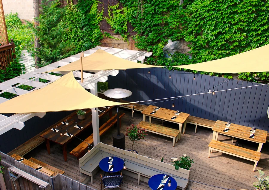 Overhead view of a shaded outdoor patio with wooden tables and benches.