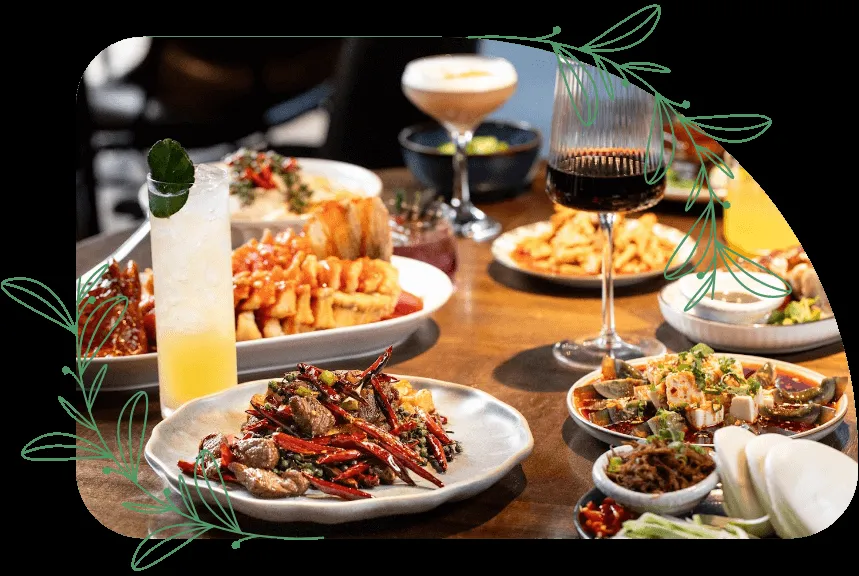 Table filled with various Asian dishes and drinks at a restaurant.