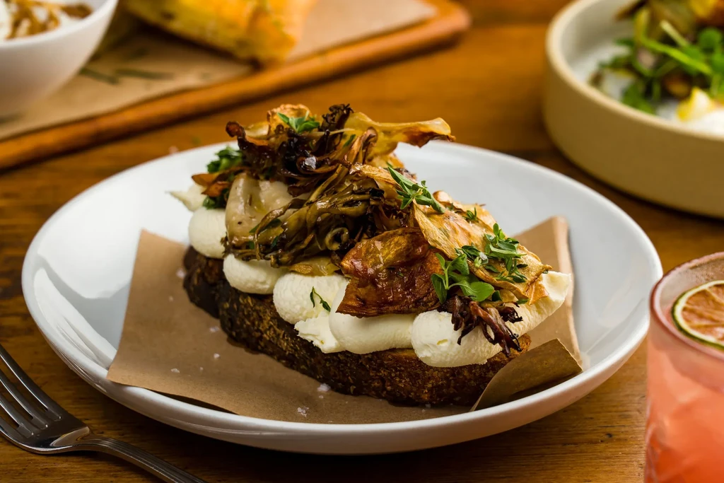 Sourdough toast with whipped cheese, roasted artichokes, and thyme.