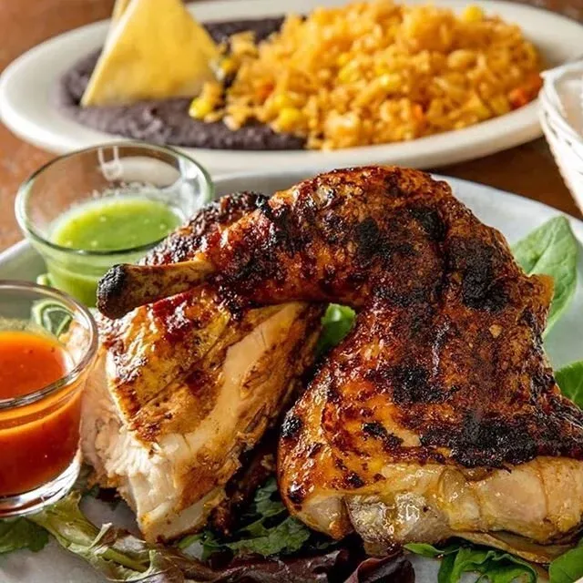 Two pieces of dark meat chicken, salsas, rice, and refried beans.