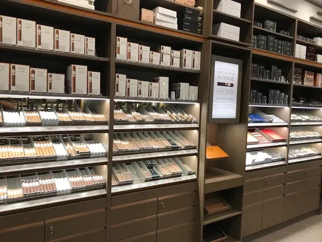 Interior view of a well-stocked cigar shop with many cigars on display.