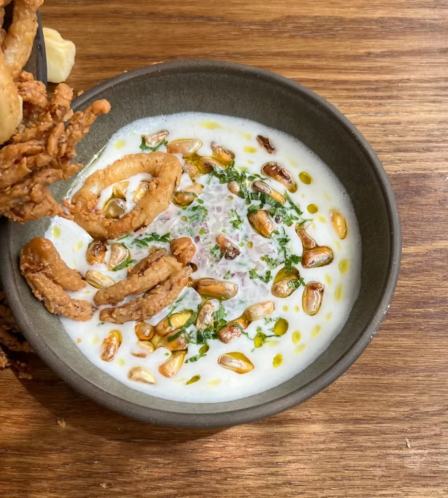 Close-up of a bowl of seafood soup with fried calamari.