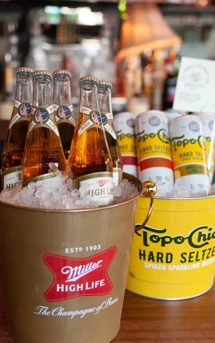 Buckets of iced Miller High Life beer and Topo Chico seltzer.