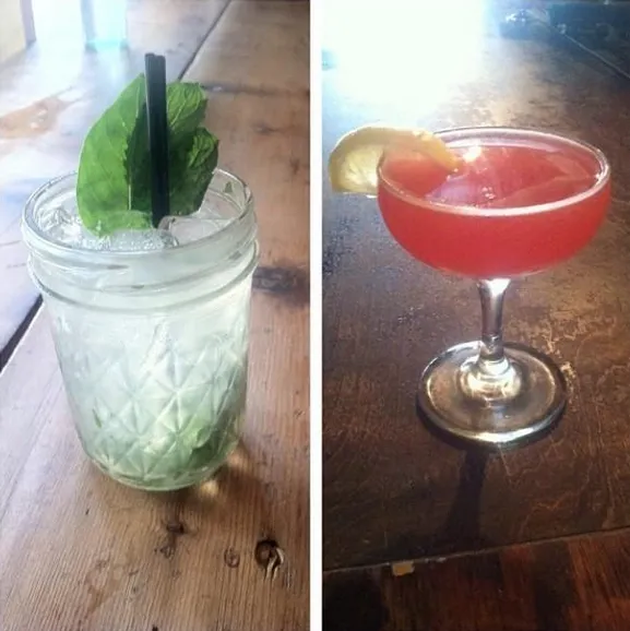 Two cocktails, a Mojito in a jar and a red drink with a lemon.