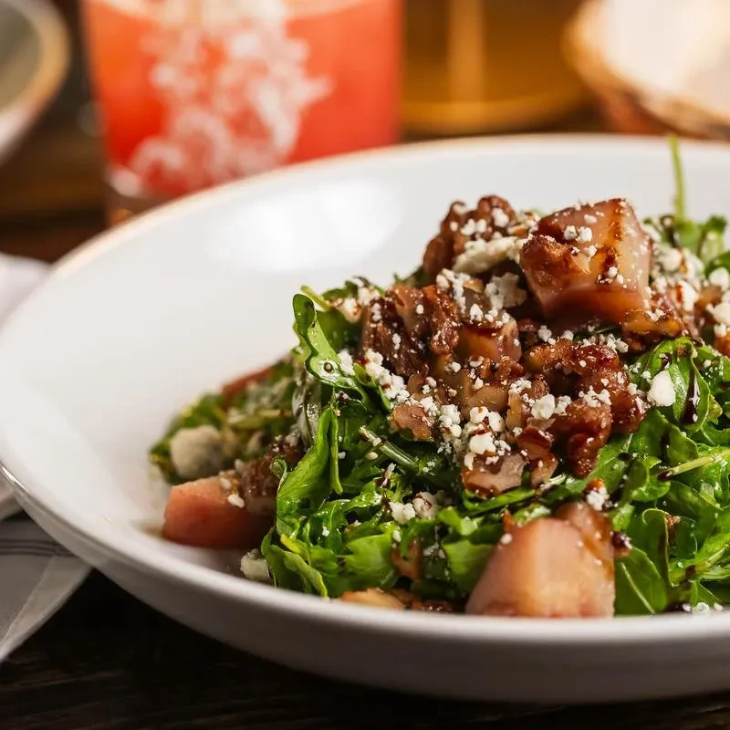 Arugula salad with blue cheese, candied walnuts, pears, and balsamic glaze.
