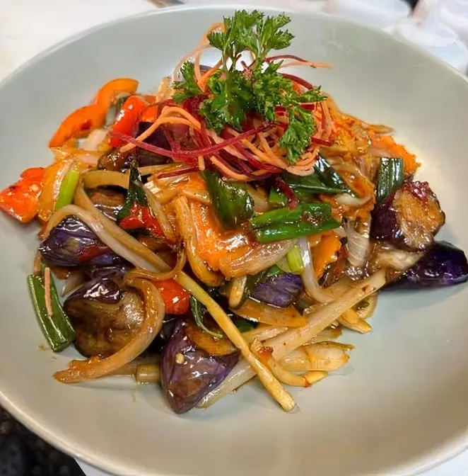 A large plate of eggplant and vegetable stir-fry.