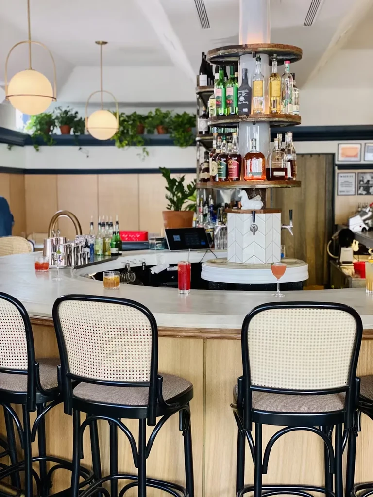Bar with high chairs and a tall, circular liquor display.