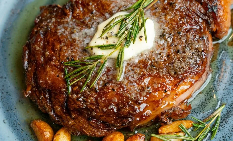 Seared steak with melting butter, rosemary, salt, and pepper.