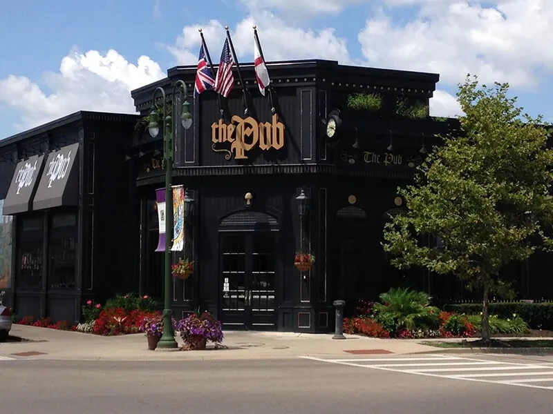 Exterior of 'The Pub' flying British, American, and English flags.