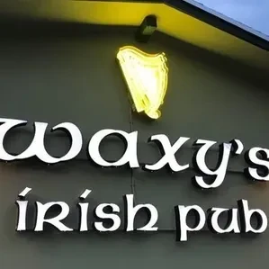 Brightly lit Waxy's Irish Pub sign with a golden neon harp.