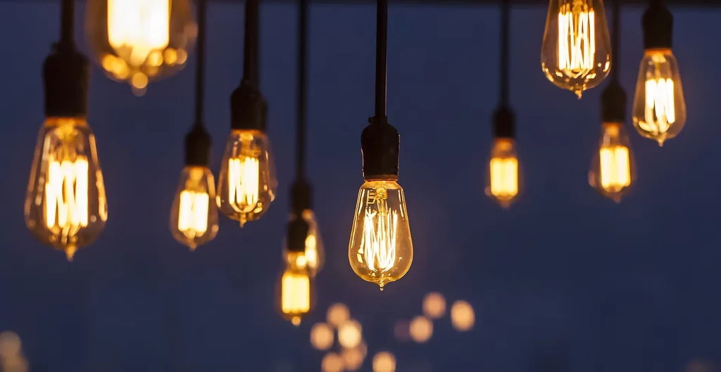 Vintage Edison bulbs with glowing filaments against a dark blue background.