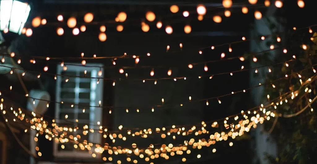 Golden string lights glow softly with a bokeh effect at night.
