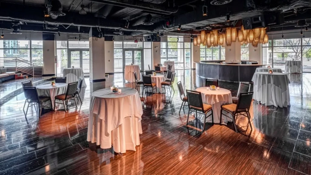 Modern, spacious bar and restaurant interior with diverse seating and large windows.