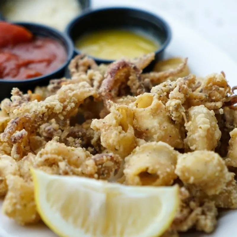 Crispy golden fried calamari, lemon wedge, and three dipping sauces.