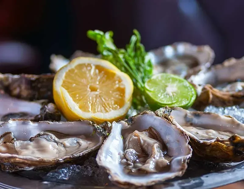 Fresh shucked oysters on crushed ice with lemon, lime, and herbs.
