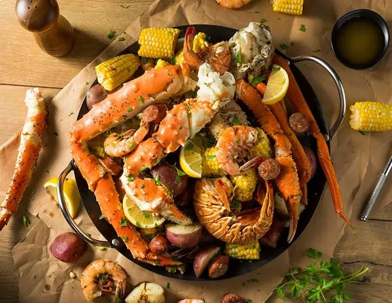 Seafood boil with crab, shrimp, corn, potatoes, sausage, and lemon.