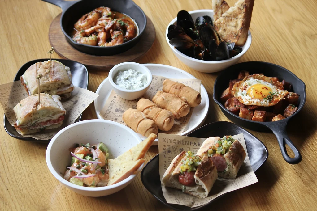 Various appetizers: shrimp, mussels, potatoes, hot dogs, salmon, rolls, sandwiches.