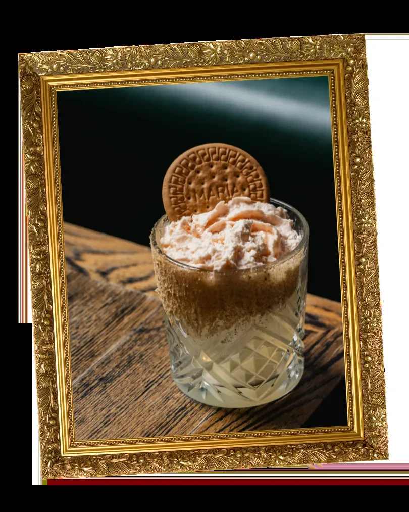 Framed image of dessert in faceted glass with biscuit garnish.