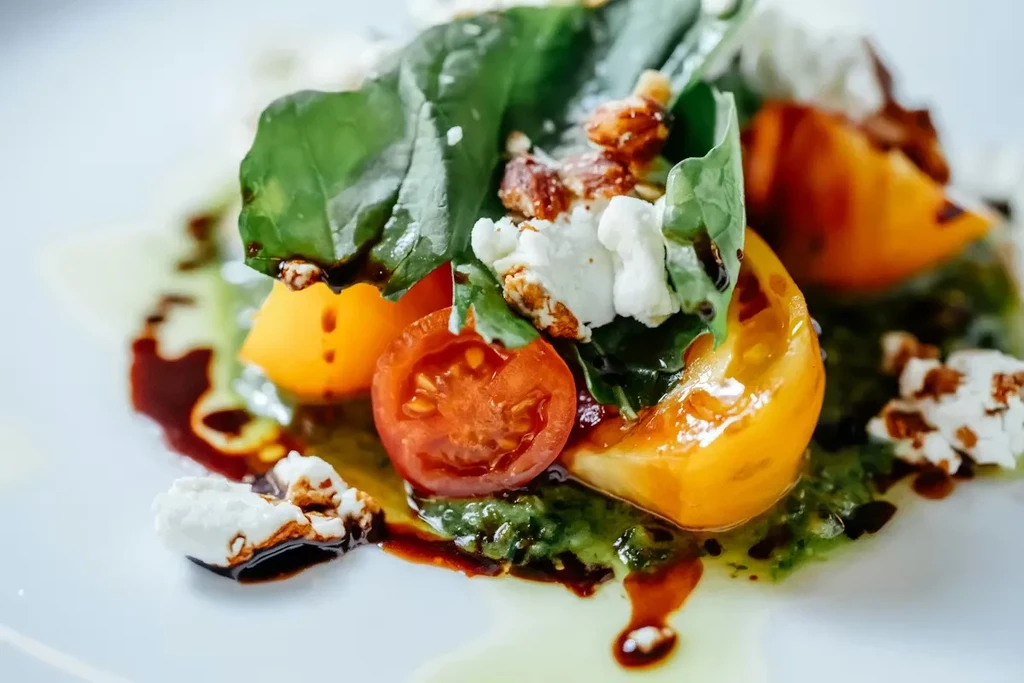 Vibrant salad with tomatoes, cheese, nuts, and balsamic drizzle.