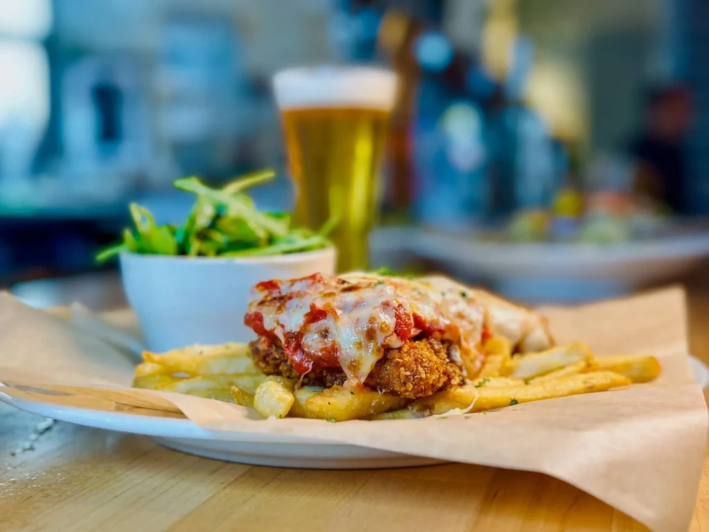 Breaded chicken or fish with cheese, red sauce, fries, and salad.