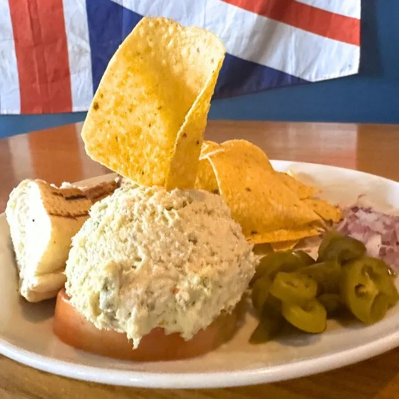 Creamy salad on tomato slice with tortilla chips and jalapeños.