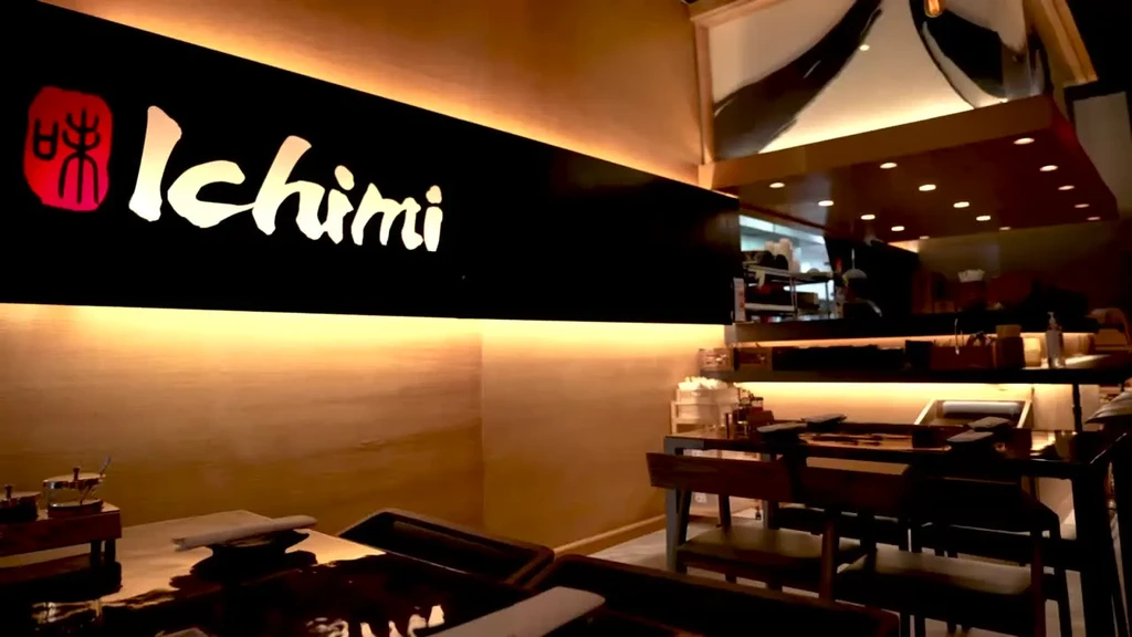 Warmly lit modern restaurant interior with Ichimi sign and dining area.