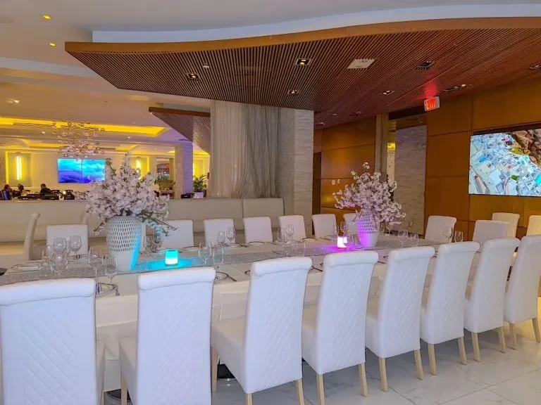 Elegant restaurant dining table with white flowers and LED candles.