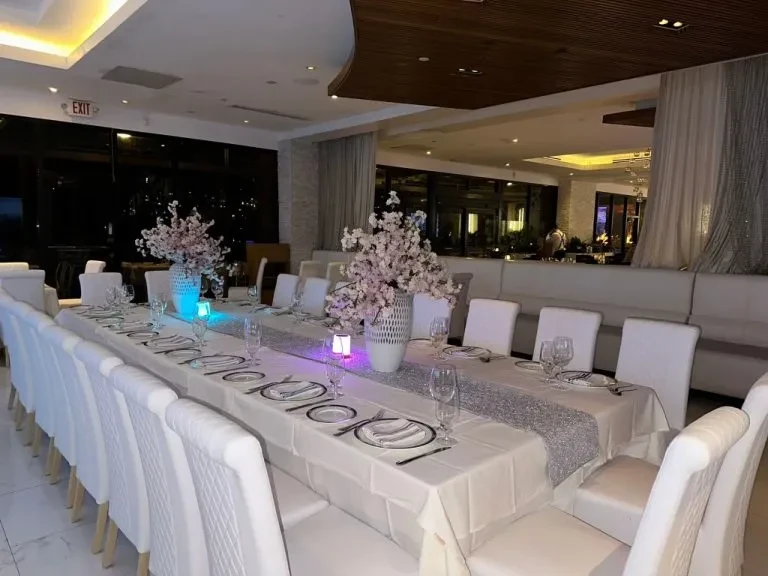Elegant dining table with silver sequined runner, cherry blossoms, and LED lights.