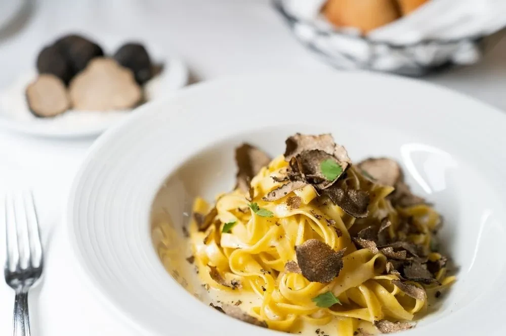 Creamy tagliatelle pasta topped with shaved black truffles.