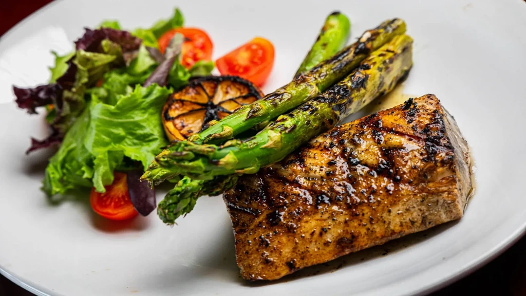 Grilled fish, charred asparagus, lemon, and fresh mixed green salad.