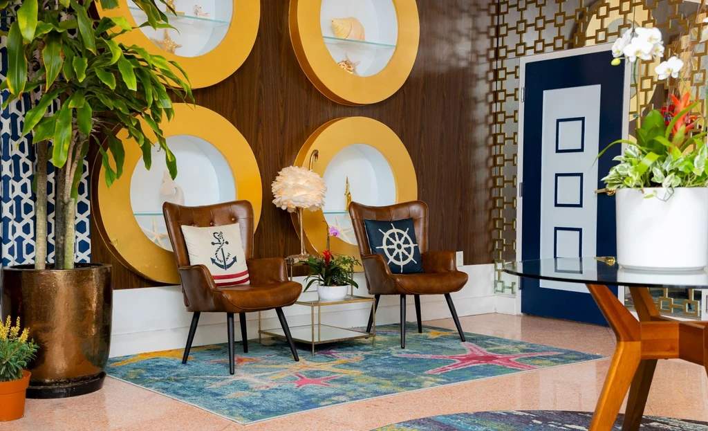 Nautical lounge with leather armchairs, starfish rug, and decorative niches.