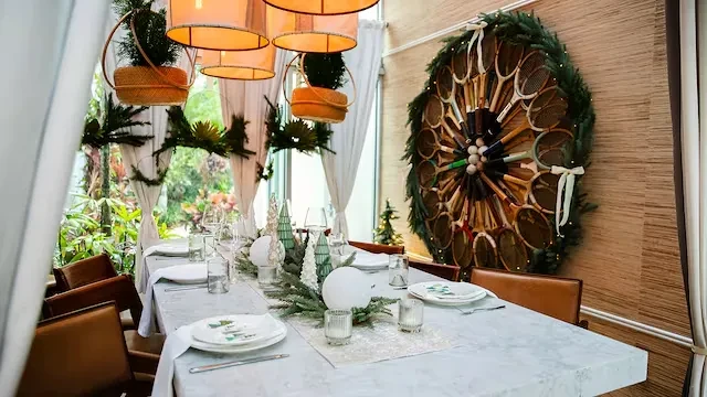 Festive restaurant dining table with unique tennis racket wall decor.