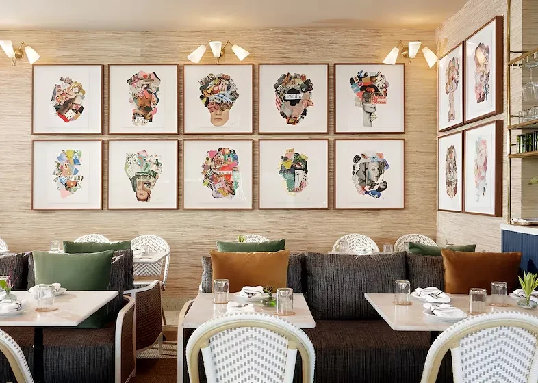 Modern restaurant dining room with prominent gallery wall of abstract art.