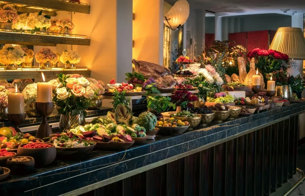 Elegant marble counter laden with buffet food, flowers, and lit candles.