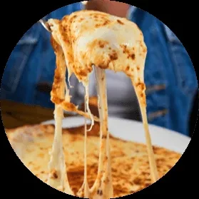 Hand lifts melted, seasoned cheese, forming long, stretchy strands.