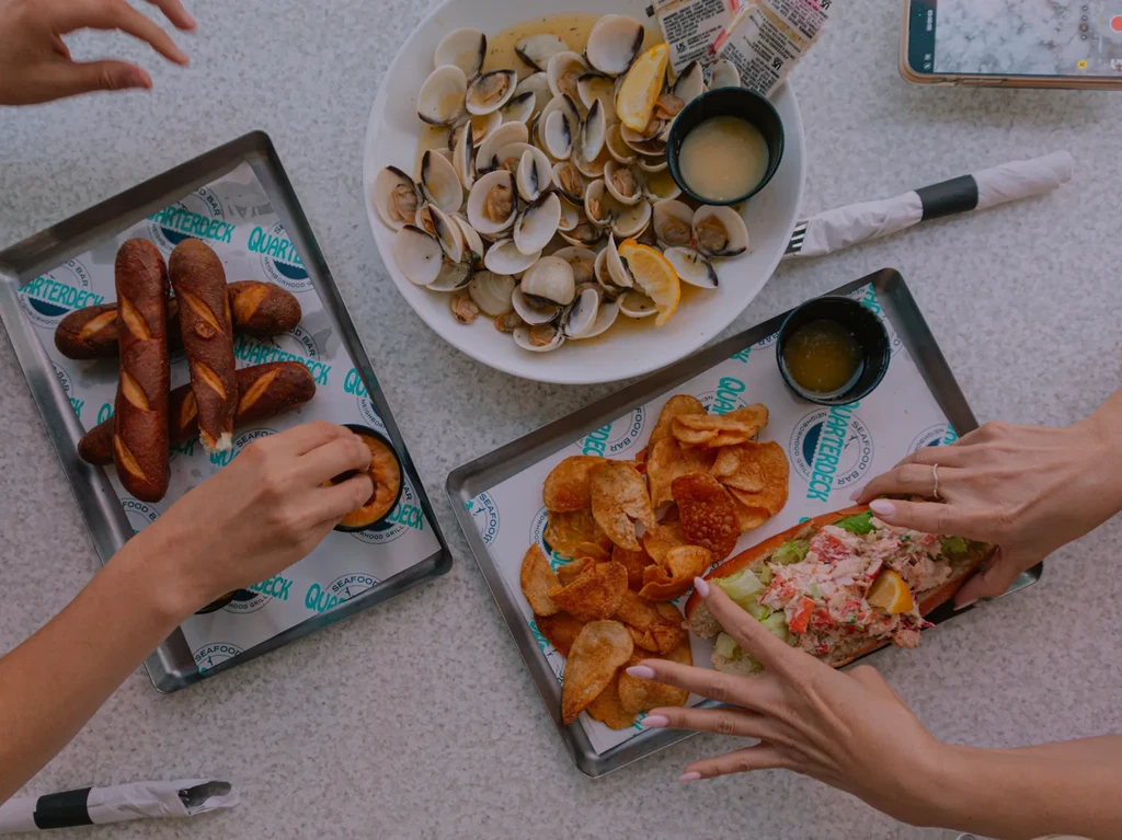 Quarterdeck restaurant table with clams, bread, seafood roll, and chips.