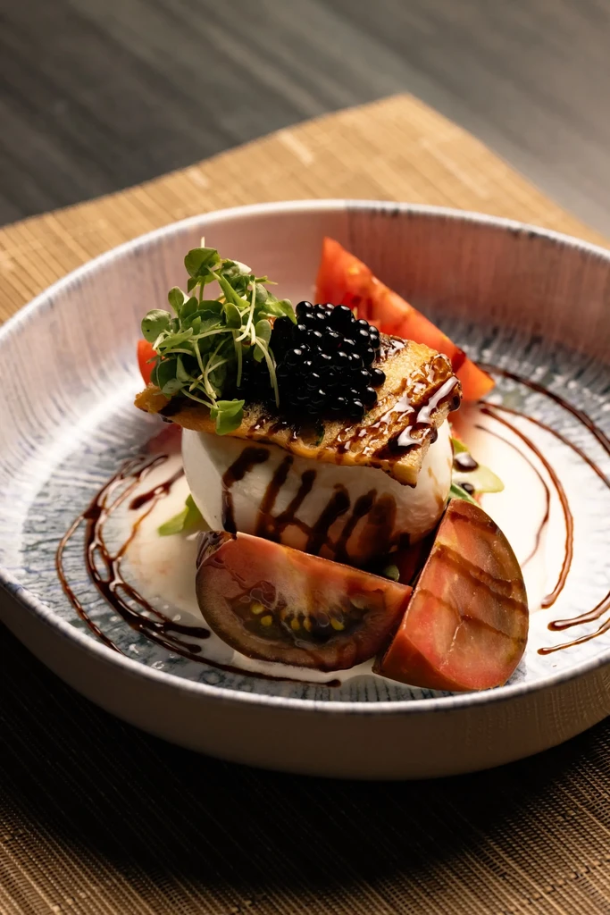 Meticulously plated burrata, caviar, heirloom tomatoes, microgreens, balsamic glaze.