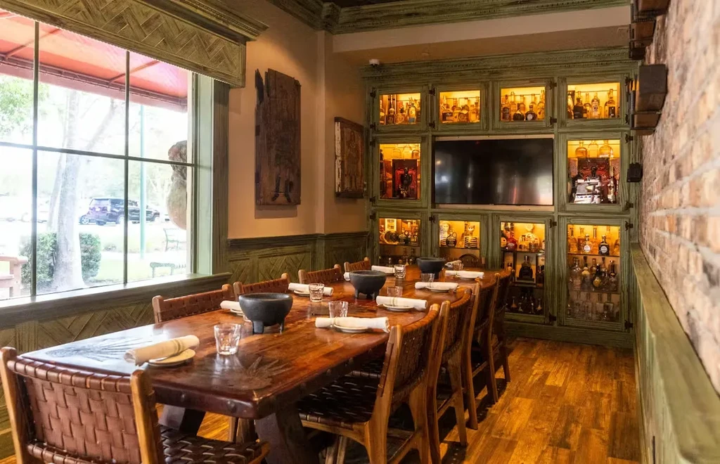 Restaurant private dining room with set table and large liquor cabinet.